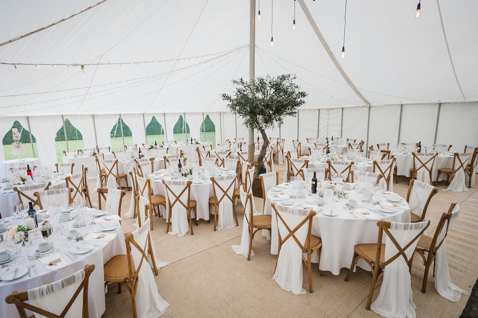 private home marquee wedding, laid out with white chair sashes and simple table settings
